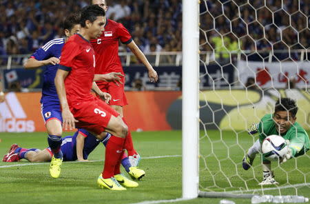 Singapore's goalkeeper Izwan Mahbud (R) saves the shot from Japan's Shinji Okazaki (L, background) during their 2018 World Cup qualifying soccer match at Saitama Stadium in Saitama, north of Tokyo June 16, 2015. REUTERS/Issei Kato