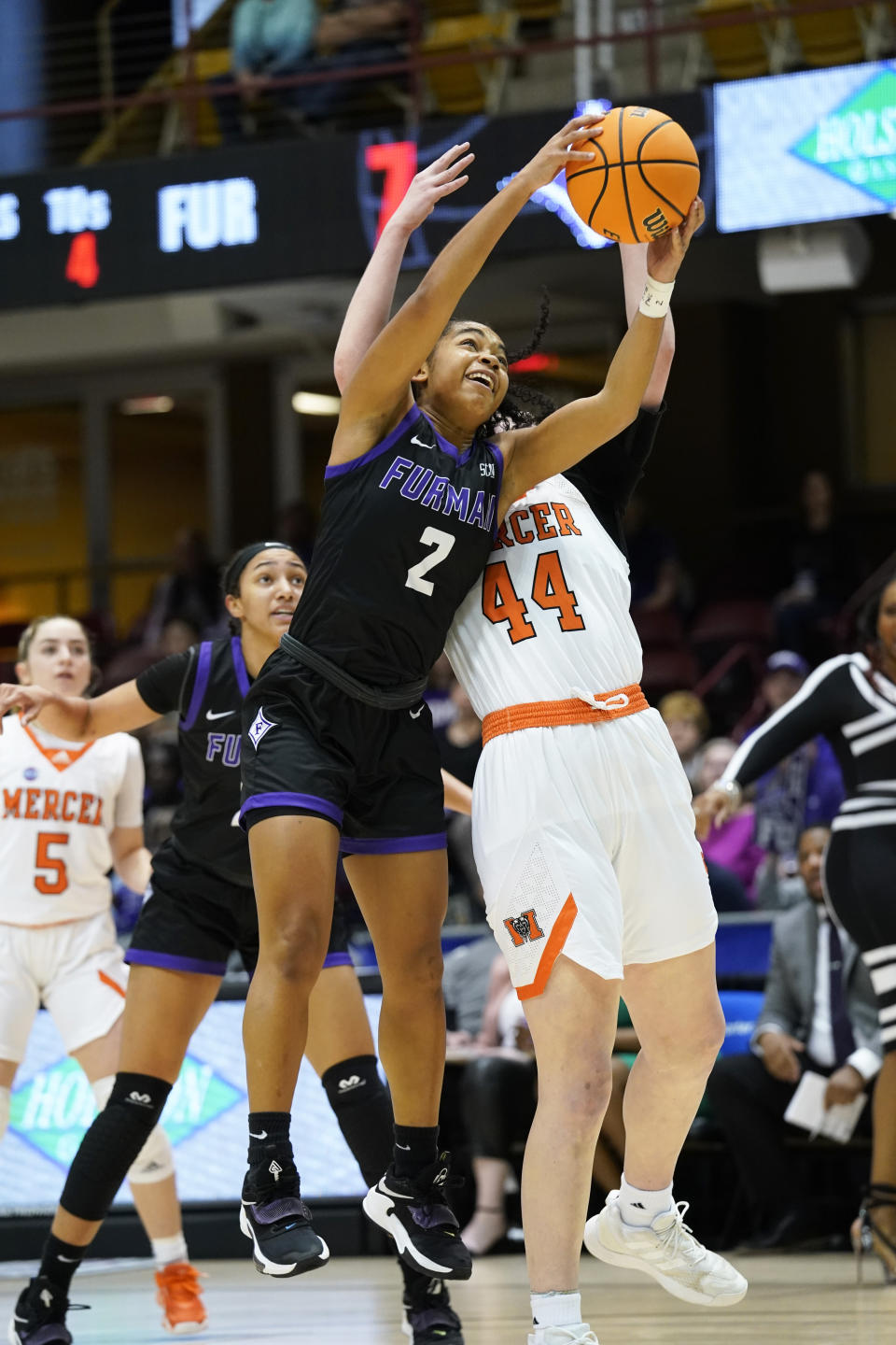 Furman guard Janay Outten (2) grabs a rebound in front of Mercer forward Allie Thayne (44) in the first half of an NCAA college basketball championship game for the Southern Conference tournament, Sunday, March 6, 2022, in Asheville, N.C. (AP Photo/Kathy Kmonicek)