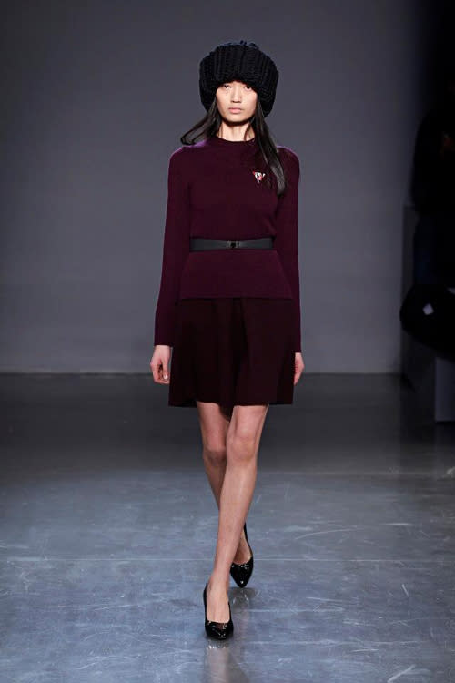 Plum jumper and skirt combination with warm winter hat.<br><br>©Facebook/Victoria Beckham