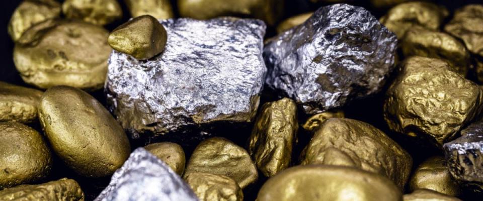 Gold- und Silbernuggets auf schwarzem Hintergrund. Edelsteine, Luxuskonzept und Mineraldrainage. Industrielle Tätigkeit, Schatz und Vermögen.