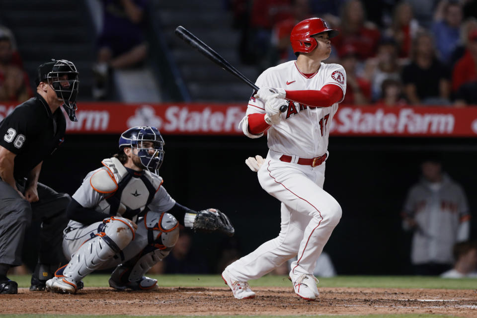 Los Angeles Angels' Shohei Ohtani watches his two-run home run next to Detroit Tigers catcher Eric Haase, center, and umpire Ryan Blakney during the fifth inning of a baseball game in Anaheim, Calif., Friday, June 18, 2021. (AP Photo/Alex Gallardo)