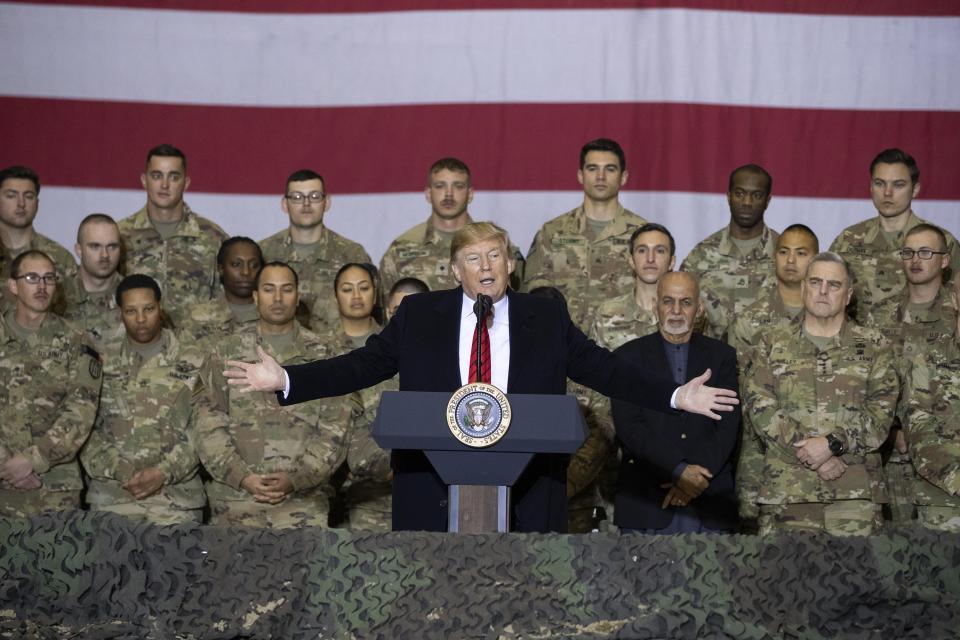 FILE - In this Nov. 28, 2019 file photo, President Donald Trump, center, with Afghan President Ashraf Ghani and Joint Chiefs Chairman Gen. Mark Milley, behind him at right, addresses members of the military during a surprise Thanksgiving Day visit at Bagram Air Field, Afghanistan. President Donald Trump starts the new year knee-deep in daunting foreign policy challenges at the same time he'll have to deal with a likely impeachment trial in the Senate and the demands of a reelection campaign. (AP Photo/Alex Brandon, File)