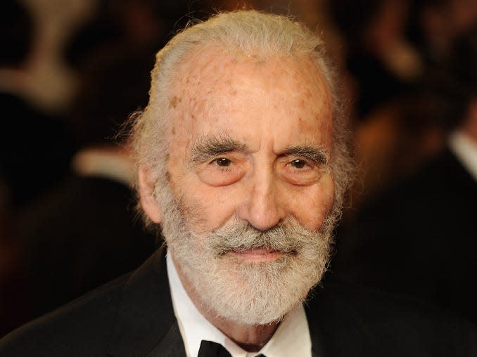 christopher lee wearing a black suit and white button down