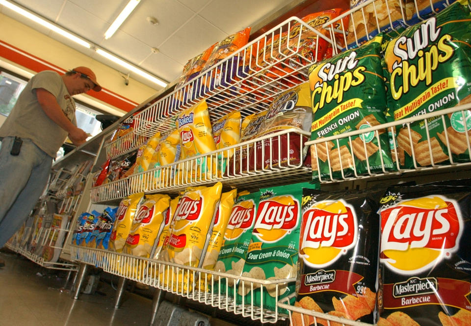 A convienence store customer make a purchase next to a shelf of Frito-Lay snacks, Tuesday, July 12, 2005, in Boston. PepsiCo Inc., which owns Frito-Lay snacks in addition to Quaker Foods and its flagship soft drink business, on Tuesday reported a 13 percent rise in second-quarter earnings. (AP Photo/Lisa Poole)