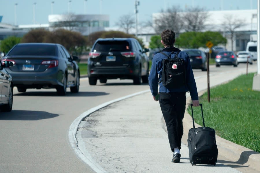 A passenger walks on the highway as he carries his luggage to at O’Hare International Airport in Chicago, Monday, April 15, 2024. Pro-Palestinian demonstrators blocked a freeway leading to three Chicago O’Hare International Airport terminals Monday morning, temporarily stopping vehicle traffic into one of the nation’s busiest airports and causing headaches for travelers. (AP Photo/Nam Y. Huh)