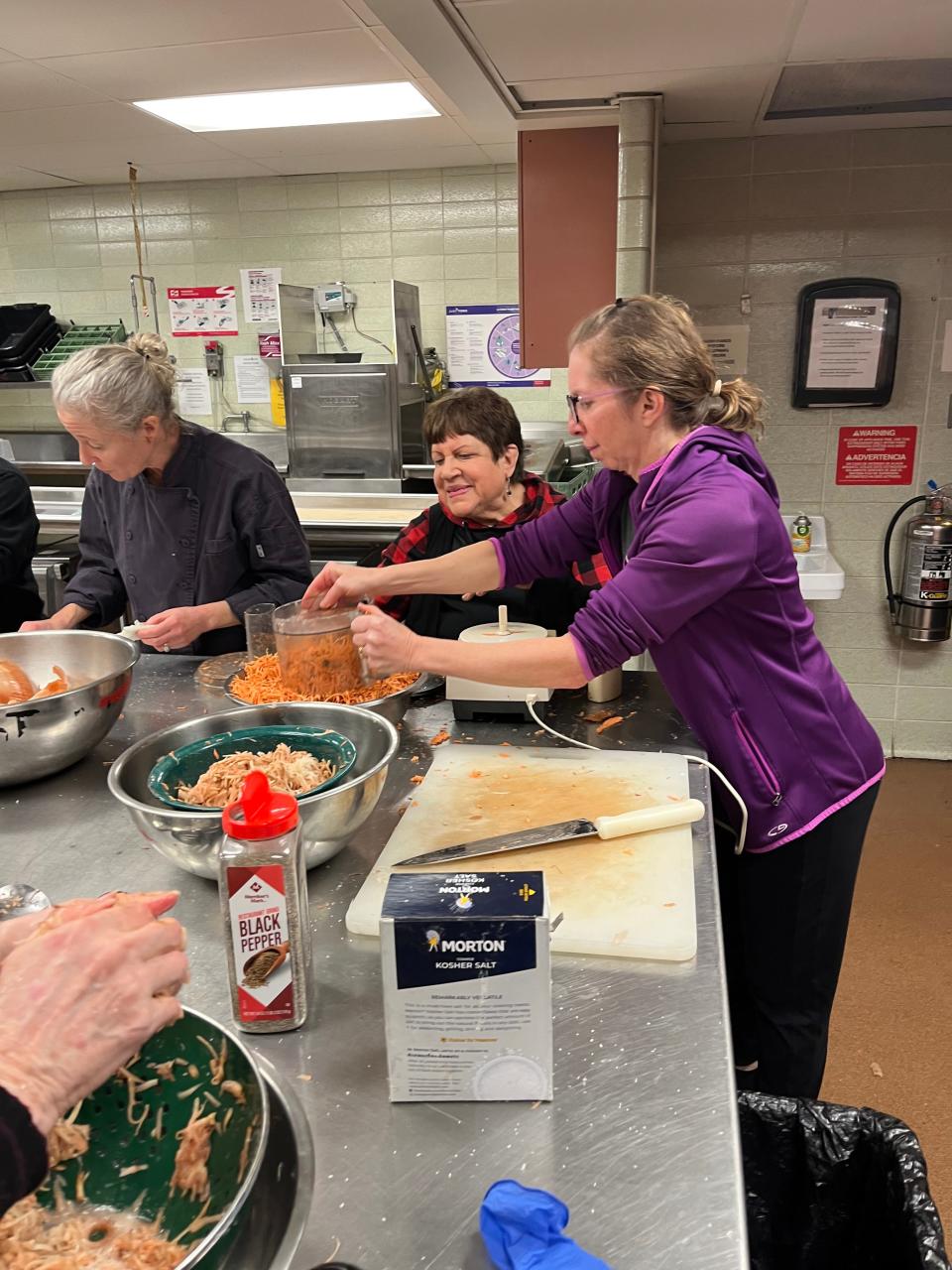Julie Weinshel (left to right), Diane Sobel and Jenni Goldbaum shred potatoes for latkes at Congregation Sinai.