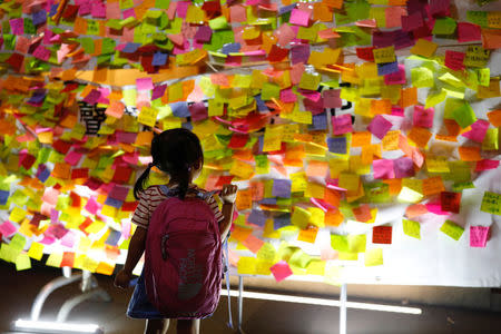 A child looks at messages in support of student leaders Joshua Wong, Nathan Law and Alex Chow who were imprisoned for their participation of the 2014 pro-democracy Umbrella Movement, also known as "Occupy Central" protests on a wall, during a protest in Hong Kong, China August 20, 2017. REUTERS/Tyrone Siu