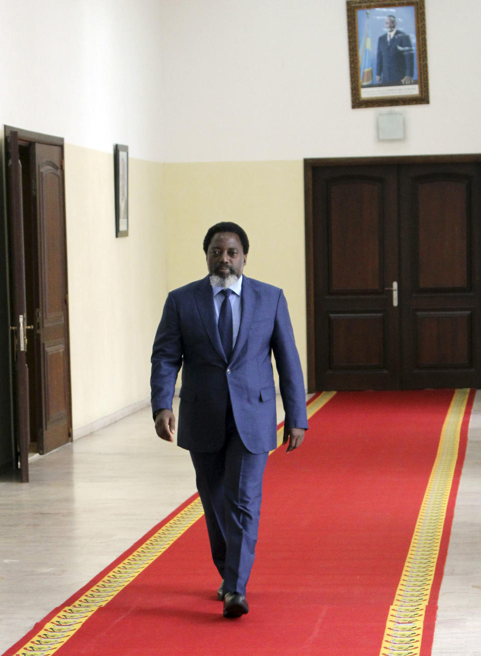 Democratic Republic of Congo's President Joseph Kabila walks to interview by the Associated Press at the Nation's Palace in Kinshasa Sunday Dec. 9, 2018. Kabila is stepping down after this month's election but he doesn't rule out seeking the post again in the future. Kabila said he hopes to continue to be active in tackling the vast challenges that remain in this mineral-rich but "complicated nation." (AP Photo/John Bompengo)