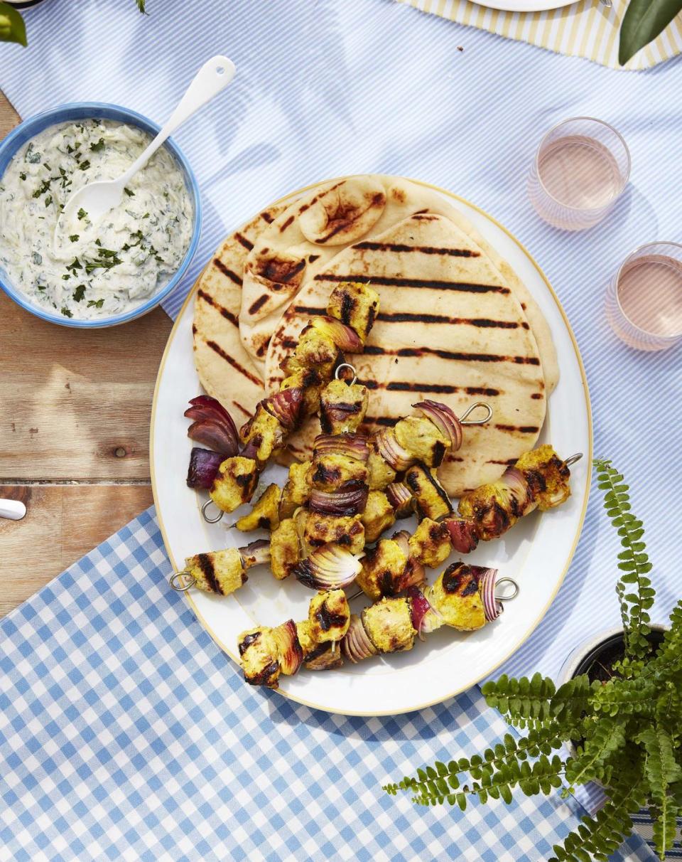 marinated chicken and onion kebabs on a white oval serving tray