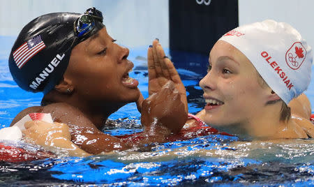 2016 Rio Olympics - Swimming - Final - Women's 100m Freestyle Final - Olympic Aquatics Stadium - Rio de Janeiro, Brazil - 11/08/2016. Simone Manuel (USA) of USA and Penelope Oleksiak (CAN) of Canada celebrate winning joint gold medals and also jointy breaking an Olympic record. REUTERS/Dominic Ebenbichler