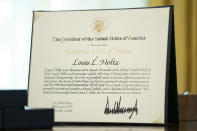 A citation sits on the Resolute Desk before President Donald Trump presented the Presidential Medal of Freedom to former football coach Lou Holtz, in the Oval Office of the White House, Thursday, Dec. 3, 2020, in Washington. (AP Photo/Evan Vucci)