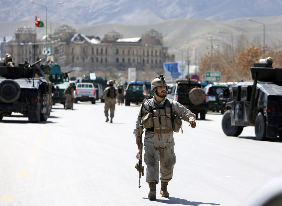 Afghan security officers arrive to the scene after two suicide bombers have struck near the home of candidate running for president, Ashraf Ghani Ahmadzai in the country's April 5 elections, in Kabul, Afghanistan, Tuesday, March 25, 2014. An Afghan police official said two suicide bombers were dead but another four insurgents may still be inside the election commission office. Witnesses reported heavy gunfire and scores of heavily armed troops with Afghanistan’s rapid response force had surrounded the building, located near the home of Ahmadzai. (AP Photo/Rahmat Gul)