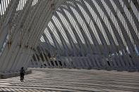 A commuter walks through the Agora structure at the Athens 2004 Olympic Complex in Athens July 25, 2014. Ten years after Greece hosted the world's greatest sporting extravaganza, many of its once-gleaming Olympic venues have been abandoned while others are used occasionally for non-sporting events such as conferences and weddings. For many Greeks who swelled with pride at the time, the Olympics are now a source of anger as the country struggles through a six-year depression, record unemployment, homelessness and poverty. Just days before the anniversary of the Aug. 13-29 Games in 2004, many question how Greece, among the smallest countries to ever host the Games, has benefited from the multi-billion dollar event. Picture taken July 25, 2014. REUTERS/Yannis Behrakis (GREECE - Tags: SOCIETY SPORT POLITICS BUSINESS) ATTENTION EDITORS: PICTURE 02 OF 33 FOR WIDER IMAGE PACKAGE 'TEN YEARS ON - ATHENS' FADING OLYMPIC STADIUMS' TO FIND ALL IMAGES SEARCH 'BEHRAKIS KARAHALIS'