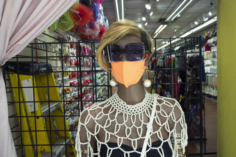 A mannequin in Bejeweled clothing store wears a mask, Tuesday, June 9, 2020, in Mount Vernon, N.Y. Counties north of New York City are reopening clothing stores as part of Phase 2 during the coronavirus pandemic. (AP Photo/Mark Lennihan)