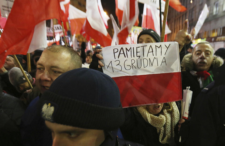 An pro-government activist carries a placard which reads "We remember 13 December" as she marches past pro-government activists during a demonstration to mark the 35th anniversary of the marshal law in Warsaw, Poland, Tuesday, Dec. 13, 2016.(AP Photo/Czarek Sokolowski)