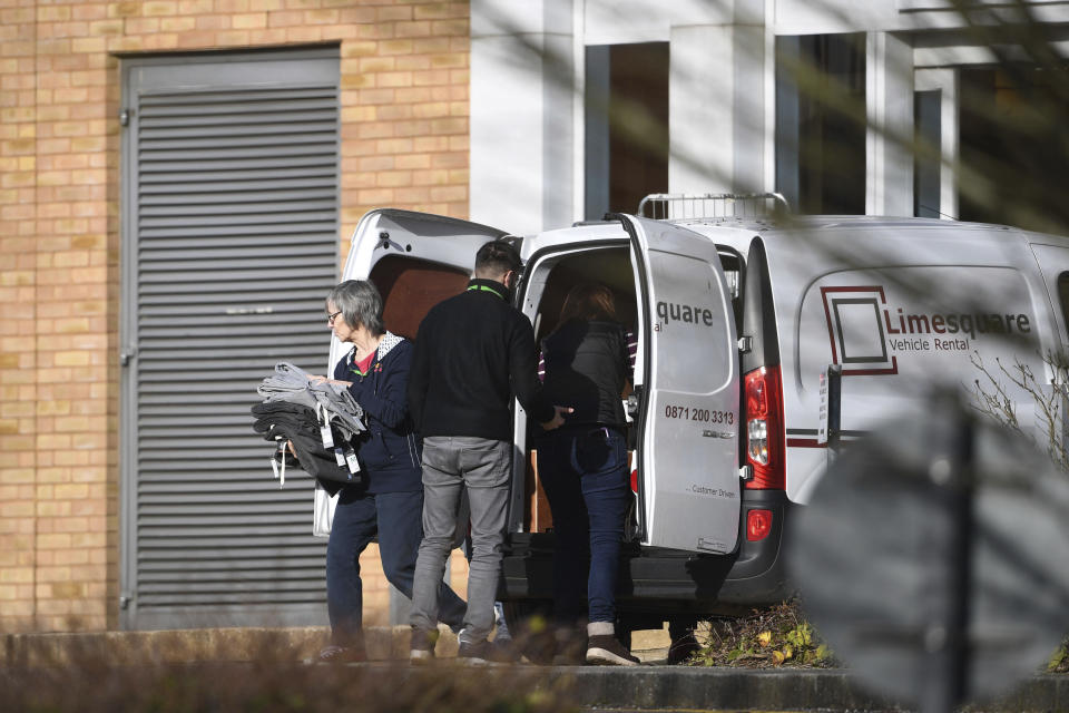 Items of clothing are taken into Kents Hill Park Training and Conference Centre, ahead of the repatriation to the UK of the latest Coronavirus evacuees who are due to land at RAF Brize Norton on Sunday, in Milton Keynes, England, Saturday, Feb. 8, 2020. A viral outbreak that began in China has infected more than 34,800 people worldwide. (Joe Giddens/PA via AP)