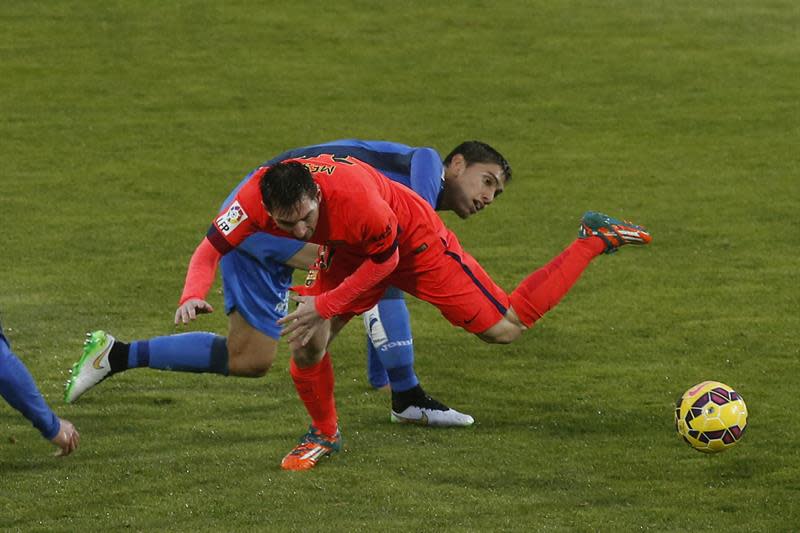 El delantero argentino del Barcelona Lionel Messi cae ante el defensa uruguayo del Getafe Emiliano Velázquez (detrás) en el partido de la decimoquinta jornada de liga en Primera División que se disputa en el Coliseo Alfonso Pérez. EFE/Juan Carlos Hidalgo