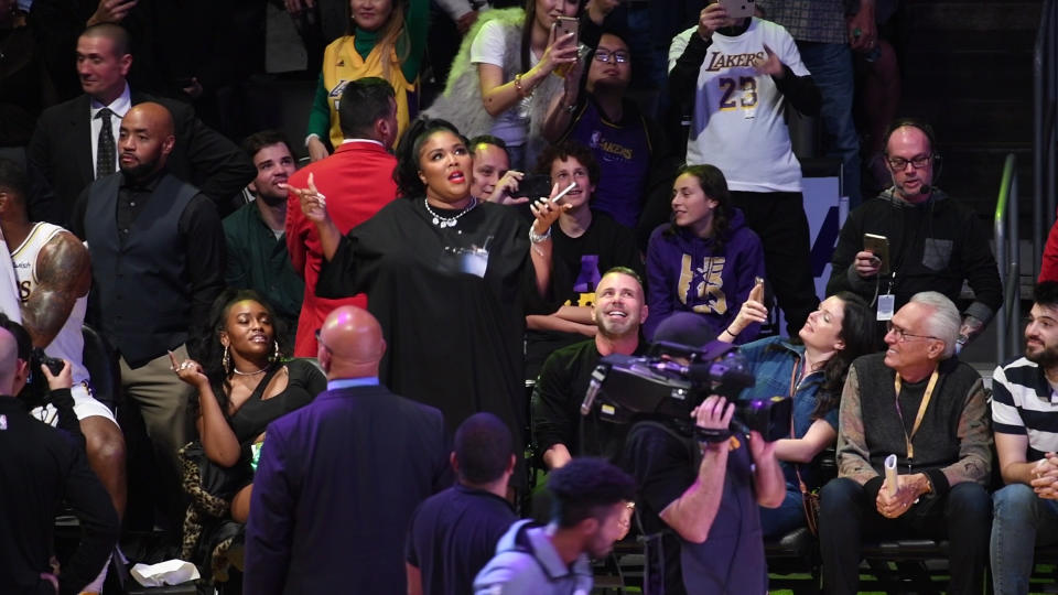 A photo of Lizzo wearing a black dress at a basketball game between the Los Angeles Lakers and the Minnesota Timberwolves at Staples Center on December 08, 2019 in Los Angeles, California