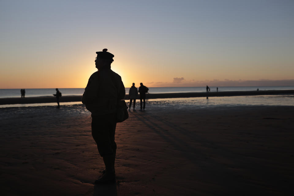 A World War II reenactor pays tribute to soldiers during a D-Day commemoration ceremony of the 78th anniversary for those who helped end World War II, in Saint-Laurent-sur-Mer, Normandy, France, Monday, June 6, 2022. (AP Photo/Jeremias Gonzalez)