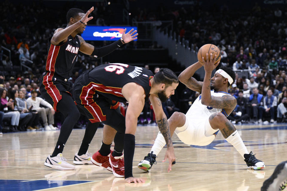 Washington Wizards guard Bradley Beal, right, looks to pass the ball as Miami Heat forward Caleb Martin (16) and forward Jamal Cain (8) defend during the first half of an NBA basketball game Friday, Nov. 18, 2022, in Washington. (AP Photo/Nick Wass)