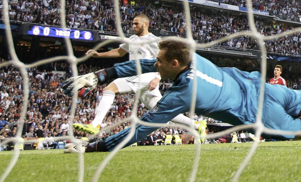 Real Madrid's Benzema scores against Bayern Munich's goalkeeper Neuer during their Champions League semi-final first leg soccer match at Santiago Bernabeu stadium in Madrid