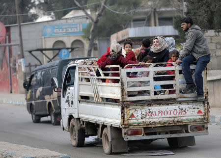 Kurdish civilians ride on the back of a truck with their belongings in Afrin, Syria March 18, 2018. REUTERS/Khalil Ashawi