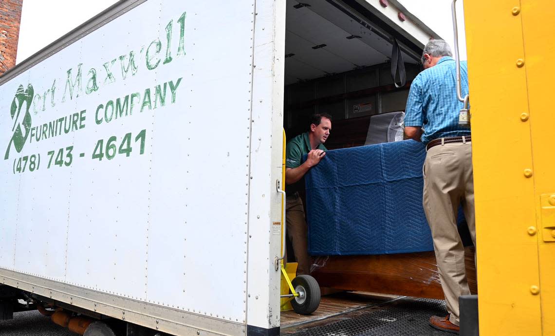 Bert Maxwell IV, left, and Bert Maxwell III transfer furniture over to the store’s delivery truck Wednesday morning. The store celebrates its 50th anniversary July 4th.