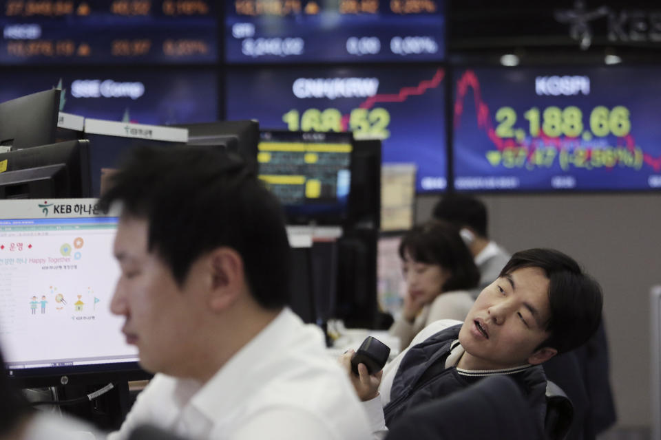 A currency trader watches monitors at the foreign exchange dealing room of the KEB Hana Bank headquarters in Seoul, South Korea, Tuesday, Jan. 28, 2020. Asian shares continued to fall Tuesday, dragged down by worries about an outbreak of a new virus in China that threatens global economic growth. (AP Photo/Ahn Young-joon)