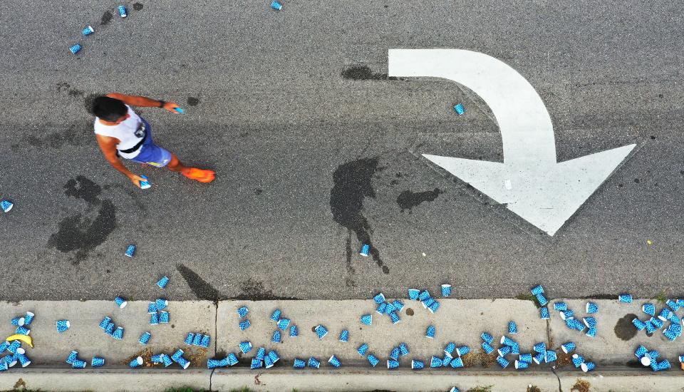 A runner gets water at an aid station during the Deseret News Marathon in Salt Lake City on Monday, July 24, 2023. | Jeffrey D. Allred, Deseret News