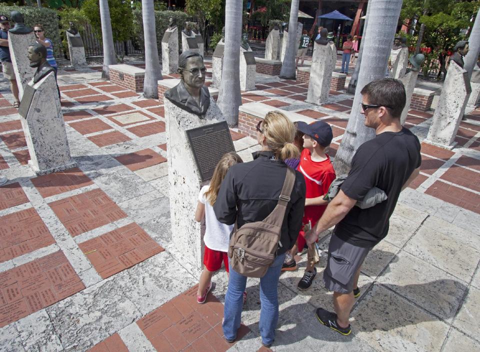 In this Wednesday, March 13, 2013, photo provided by the Florida Keys News Bureau, Kate and Matt Hover, and their three children examine a bronze bust of former President Harry S. Truman in the Key West Historic Memorial Sculpture Garden in Key West, Fla. The free-admission gardens features 38 bronze busts of prominent men and women who had a key influence on the development of Key West and the remainder of the Florida Keys. (AP Photo/Florida Keys News Bureau, Carol Tedesco)