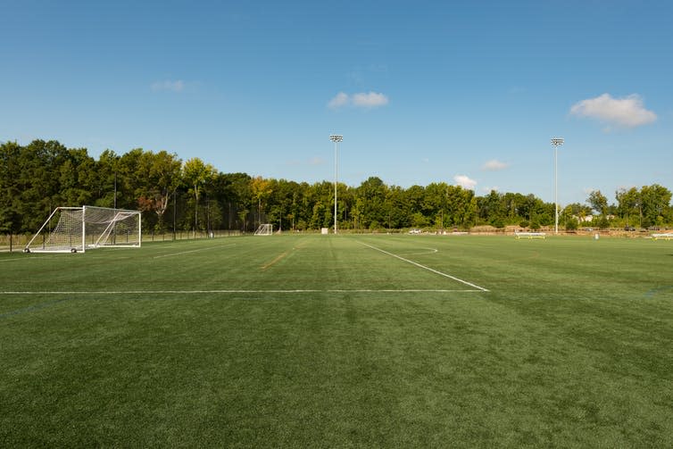 A neatly mown football field in a public park.