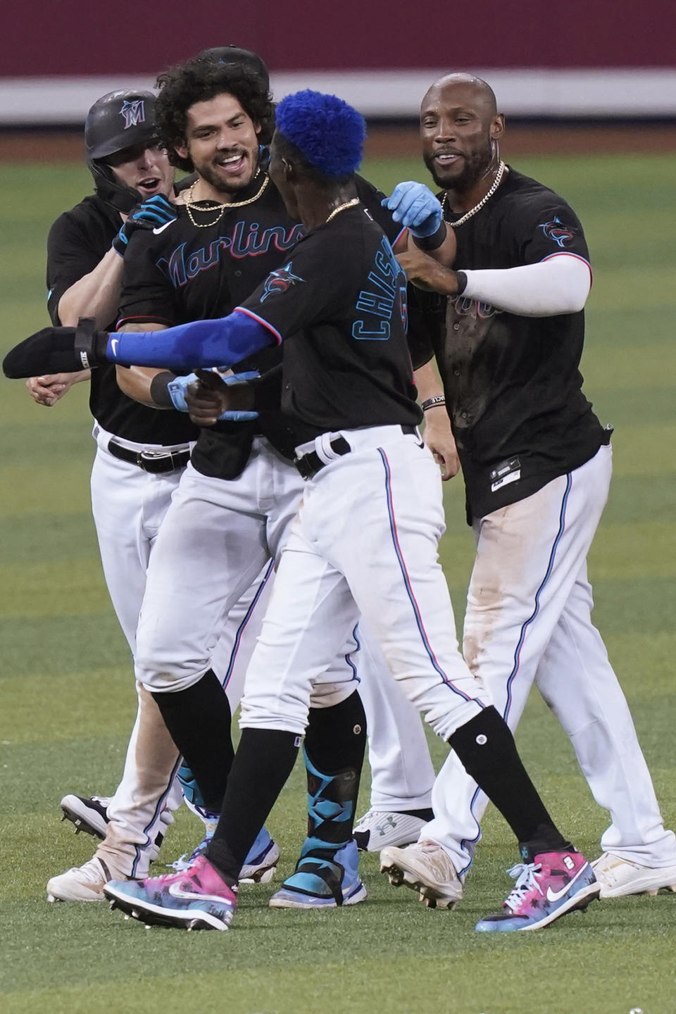 Miami Marlins' Jorge Alfaro, center, is congratulated after he hit a double to drive in the winning run in the 10th inning of the team's baseball game against the San Francisco Giants, Saturday, April 17, 2021, in Miami. The Marlins won 7-6. (AP Photo/Marta Lavandier)