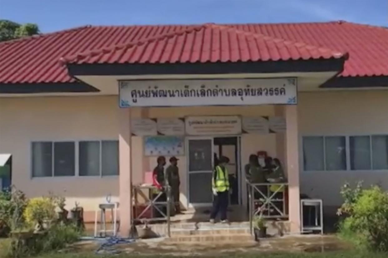 In this image taken from video, officials enter the site of an attack at a daycare center, Thursday, Oct. 6, 2022, in the town of Nongbua Lamphu, northeastern Thailand. More than 30 people, primarily children, were killed Thursday when a gunman opened fire at the childcare center, authorities said.