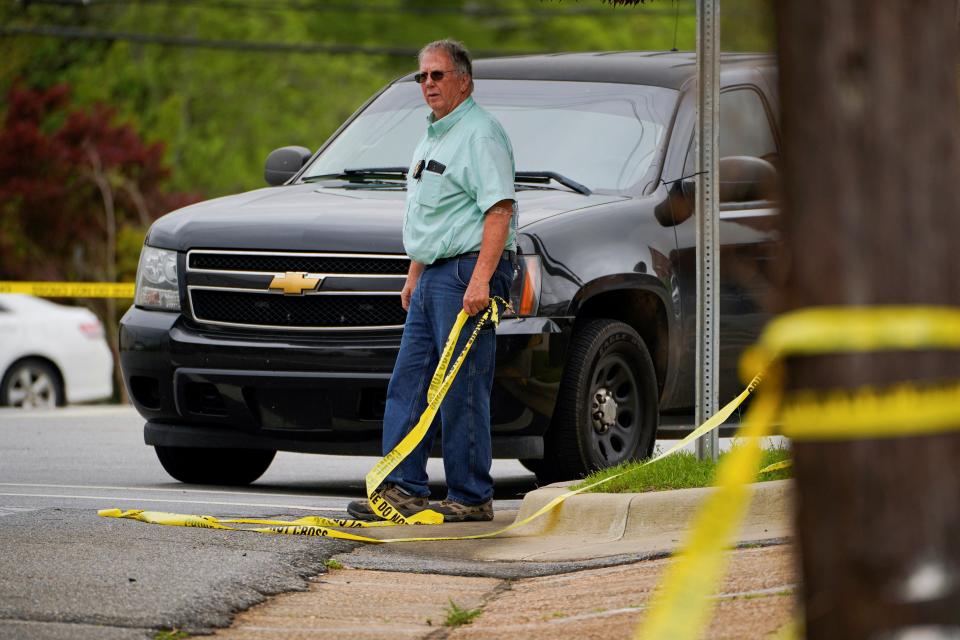 A law enforcement officer tapes off the crime scene near the Mahogany Masterpiece Dance Studio in downtown Dadeville (Cheney Orr/Reuters)