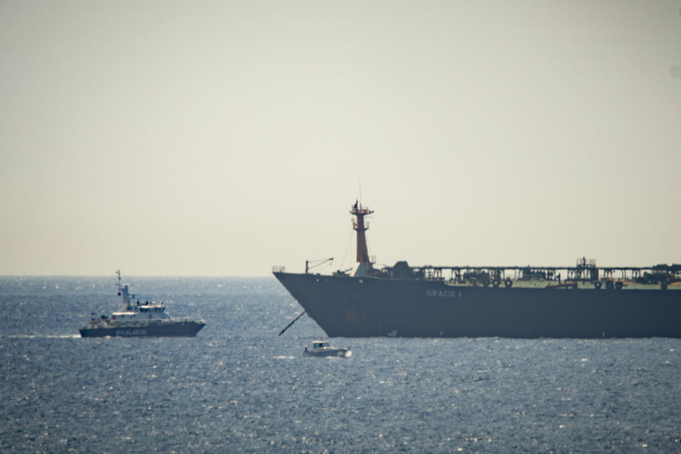 A view of the Grace 1 super tanker near a Royal Marine patrol vessel in the British territory of Gibraltar, Thursday, July 4, 2019. Spain's acting foreign minister says a tanker stopped off Gibraltar and suspected of taking oil to Syria was intercepted by British authorities after a request from the United States. (AP Photo/Marcos Moreno)