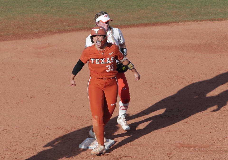 Texas' Mary Iakopo (33) celebrates after making it safely to second base in the second inning of an NCAA softball Women's College World Series game against Oklahoma State on Monday, June 6, 2022, in Oklahoma City. (AP Photo/Alonzo Adams)