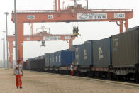 In this July 25, 2019, photo, a worker walks past a cargo train bound for Europe at a train station in Dalian in northeastern China's Liaoning Province. Authorities in China's rust-belt region are looking for support for its revival from Beijing's multibillion-dollar initiative to build ports, railways and other projects abroad. (AP Photo/Olivia Zhang)