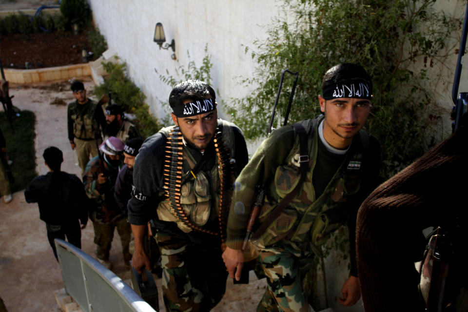 In this Wednesday, Nov. 14, 2012, file photo, Syrian fighters of "The Beloved of Allah," brigade hold their weapons before fighting with government forces on the outskirts of Aleppo. Syrians are marking 10 years since peaceful protests against President Bashar Assad's government erupted in March 2011, touching off a popular uprising that quickly turned into a full-blown civil war. (AP Photo/Khalil Hamra, File)