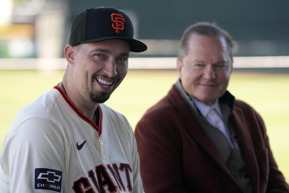 New San Francisco Giants pitcher Blake Snell, left, smiles as he is introduced during a baseball news conference as agent Scott Boras, right, listens Wednesday, March 20, 2024, in Scottsdale, Ariz. (AP Photo/Ross D. Franklin)