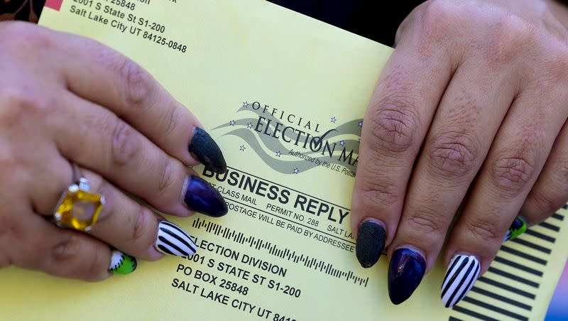 A mail-in ballot is held during a press conference at the Salt Lake City-County Building on Oct. 20, 2022.