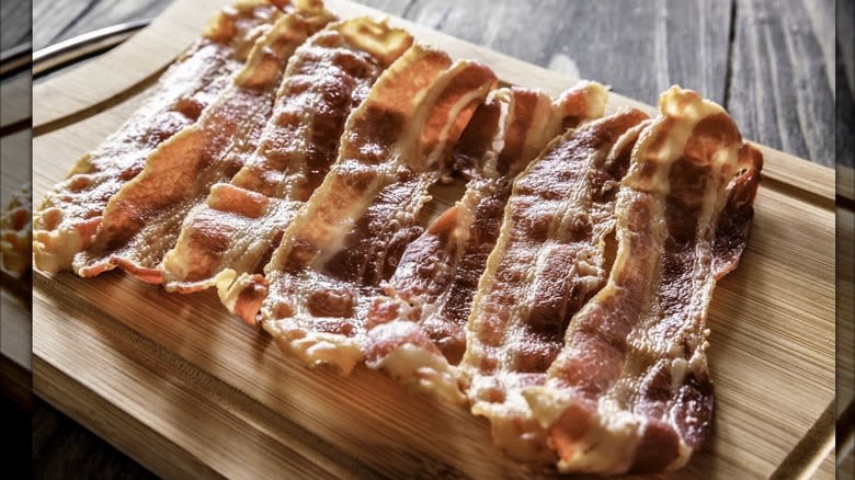 Cooked bacon on wooden board