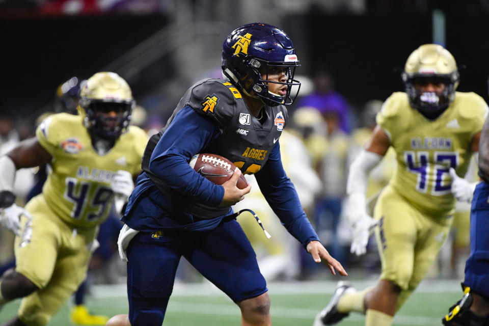 North Carolina A&T quarterback Kylil Carter rushes as Alcorn State linebacker Solomon Muhammad (49) and linebacker Daimen Anderson (42) defend during the first half of the Celebration Bowl NCAA college football game, Saturday, Dec. 21, 2019, in Atlanta. (John Amis/Atlanta Journal-Constitution via AP)