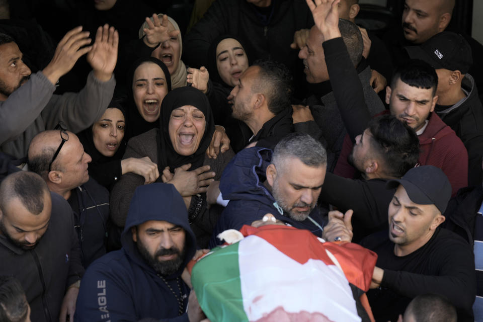 Palestinian women mourn for schoolteacher Jawad Bawaqna, 57, foreground and Adham Jabareen, 28, during their funeral in the in the West Bank city of Jenin, Thursday, Jan. 19, 2023. Palestinian officials and media reports say Israeli troops shot and killed the Palestinian schoolteacher and a militant during a military raid in the occupied West Bank. (AP Photo/Majdi Mohammed)