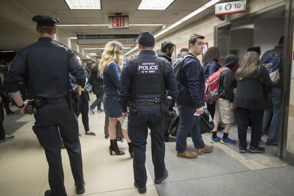 Amtrak police watch as passengers make their way to the track to board the first train to leave Penn Station after delays caused by a stuck train, Friday, April 14, 2017, in New York. A New Jersey Transit train with about 1,200 passengers aboard was stuck in a Hudson River tunnel between New York and New Jersey. (AP Photo/Mary Altaffer)