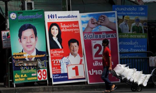 A Thai worker carries bags on a trolley past electoral posters for various candidates in Bangkok on June 28, 2011. The United States is nervously watching Sunday's election in Thailand, with policymakers worried it may set off new instability that diminishes the role of Washington's oldest Asian ally