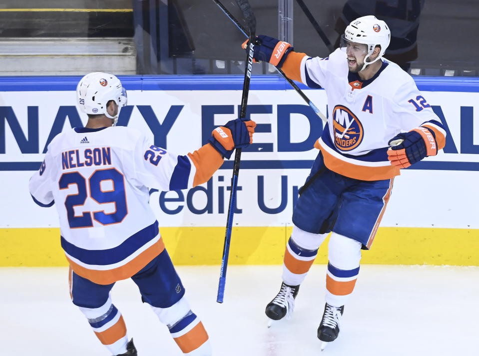 New York Islanders right wing Josh Bailey (12) celebrates his goal with teammate Brock Nelson (29) after scoring against the Washington Capitals during the third period of an NHL Eastern Conference Stanley Cup playoff hockey game in Toronto, Ontario, on Wednesday, Aug. 12, 2020. (Nathan Denette/The Canadian Press via AP)