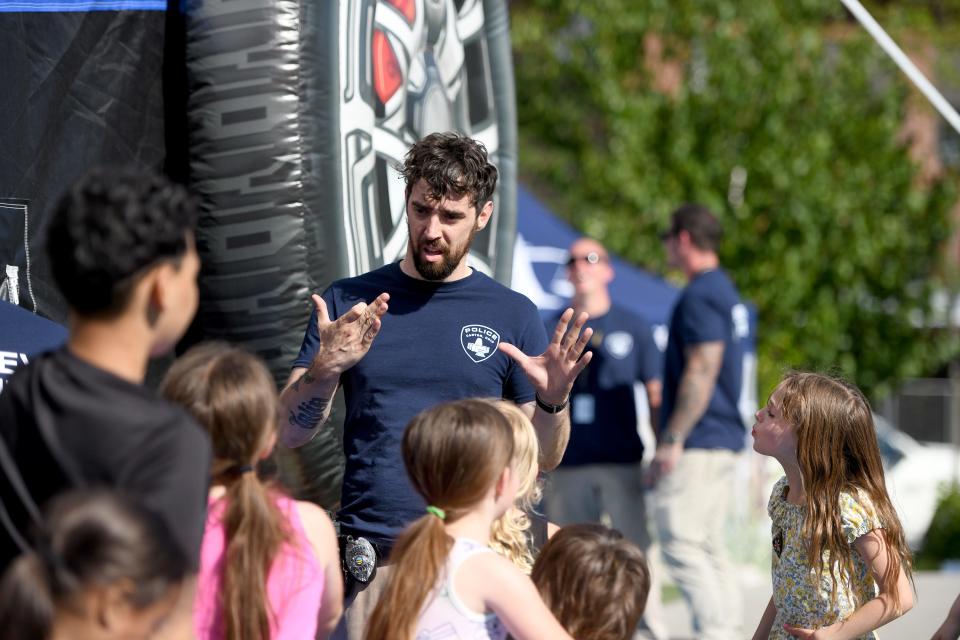 Canton police officer Jon Versiackas engages with children during this year's first Canton City Police Department-sponsored We Believe in Canton community event, which was held Wednesday at Centennial Plaza in Canton.