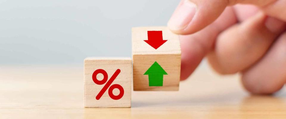 Interest rate financial and mortgage rates concept. Hand flip wood cube change arrow down to up