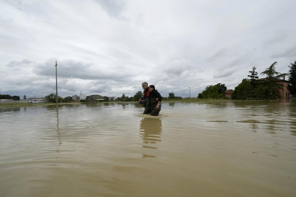 FILE - A couple walk in a flooded road of Lugo, Italy, May 18, 2023. The latest calculations from several science agencies Friday, Jan. 12, 2024, all say that global average temperatures for 2023 shattered existing heat records. (AP Photo/Luca Bruno, File)