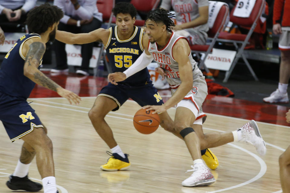 Ohio State's Justice Sueing, right, drives to the basket against Michigan's Eli Brooks during the second half of an NCAA college basketball game Sunday, Feb. 21, 2021, in Columbus, Ohio. (AP Photo/Jay LaPrete)